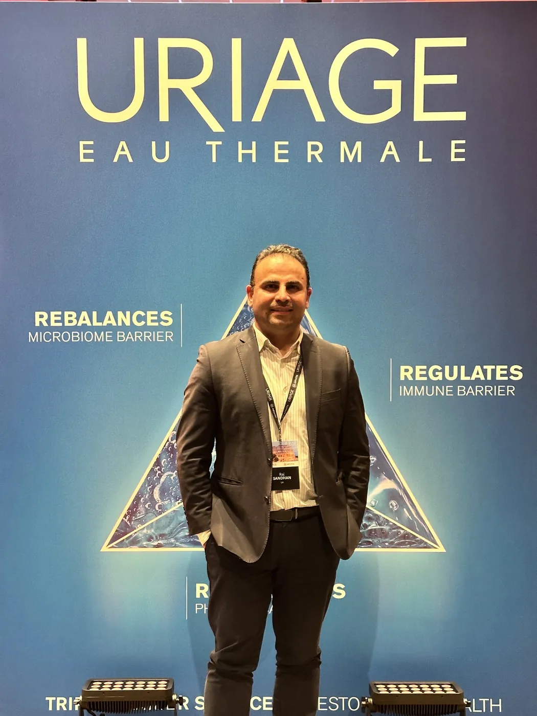 Raj Sandhan standing in front of a large Uriage Eau Thermale backdrop